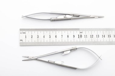 Çelik cerrahi aletler ve laboratuvar ekipmanları beyaz arka planda izole edilmiş. Profesyonel klinik aletleri. Tıbbi, cerrahi, ambulans ve veteriner konsepti. Yumuşak seçici odaklı yakın plan