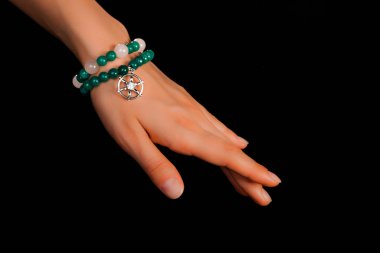 Güzel bir el yapımı mücevher bileziği. Renkli parlak boncuklar ve nötr manikürlü gevşek bir kadın bileği. Moda ve el işi aksesuarları. Yumuşak seçici odaklı yakın plan