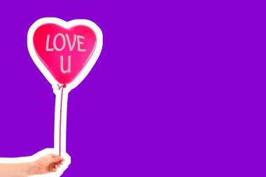 Kadın eli kırmızı kauçuk, şişme kalp şeklinde balon tutuyor. Aşk, ilişki, sevgililer günü ve doğum günü kutlaması konsepti. Boş kopya alanı olan dergi tarzı moda kolajı