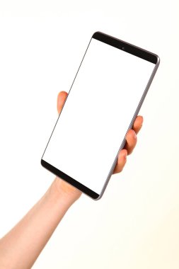 İnsan eli, avucunda boş bir krom ekran olan modern bir akıllı telefonu tutar. Teknoloji ve reklam kavramı. Ayrıntılı yakın çekim stüdyo çekimi soyut beyaz arka planda izole