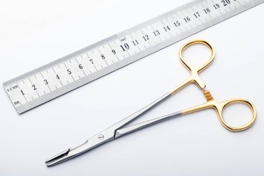 Çelik cerrahi aletler ve laboratuvar ekipmanları beyaz arka planda izole edilmiş. Profesyonel klinik aletleri. Tıbbi, cerrahi, ambulans ve veteriner konsepti. Yumuşak seçici odaklı yakın plan