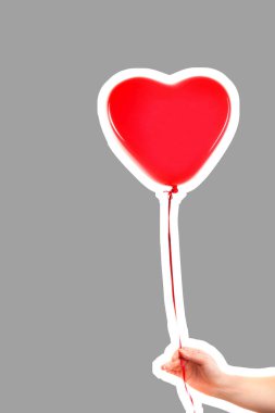 Kadın eli kırmızı kauçuk, şişme kalp şeklinde balon tutuyor. Aşk, ilişki, sevgililer günü ve doğum günü kutlaması konsepti. Boş kopya alanı olan dergi tarzı moda kolajı