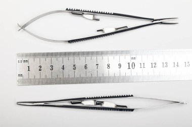 Çelik cerrahi aletler ve laboratuvar ekipmanları beyaz arka planda izole edilmiş. Profesyonel klinik aletleri. Tıbbi, cerrahi, ambulans ve veteriner konsepti. Yumuşak seçici odaklı yakın plan