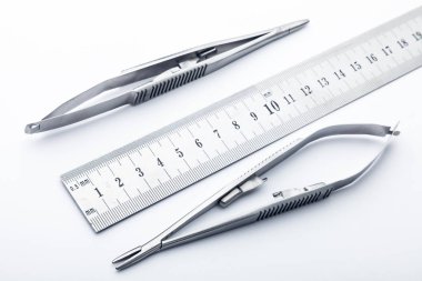 Çelik cerrahi aletler ve laboratuvar ekipmanları beyaz arka planda izole edilmiş. Profesyonel klinik aletleri. Tıbbi, cerrahi, ambulans ve veteriner konsepti. Yumuşak seçici odaklı yakın plan