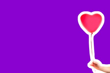 Kadın eli kırmızı kauçuk, şişme kalp şeklinde balon tutuyor. Aşk, ilişki, sevgililer günü ve doğum günü kutlaması konsepti. Boş kopya alanı olan dergi tarzı moda kolajı