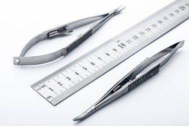 Çelik cerrahi aletler ve laboratuvar ekipmanları beyaz arka planda izole edilmiş. Profesyonel klinik aletleri. Tıbbi, cerrahi, ambulans ve veteriner konsepti. Yumuşak seçici odaklı yakın plan