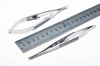 Çelik cerrahi aletler ve laboratuvar ekipmanları beyaz arka planda izole edilmiş. Profesyonel klinik aletleri. Tıbbi, cerrahi, ambulans ve veteriner konsepti. Yumuşak seçici odaklı yakın plan