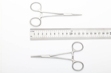 Çelik cerrahi aletler ve laboratuvar ekipmanları beyaz arka planda izole edilmiş. Profesyonel klinik aletleri. Tıbbi, cerrahi, ambulans ve veteriner konsepti. Yumuşak seçici odaklı yakın plan