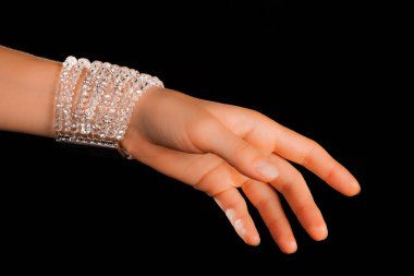 Güzel bir el yapımı mücevher bileziği. Renkli parlak boncuklar ve nötr manikürlü gevşek bir kadın bileği. Moda ve el işi aksesuarları. Yumuşak seçici odaklı yakın plan