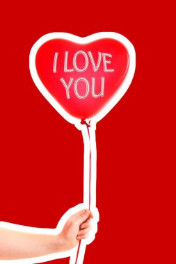 Kadın eli kırmızı kauçuk, şişme kalp şeklinde balon tutuyor. Aşk, ilişki, sevgililer günü ve doğum günü kutlaması konsepti. Boş kopya alanı olan dergi tarzı moda kolajı