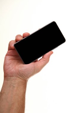 İnsan eli, avucunda boş bir krom ekran olan modern bir akıllı telefonu tutar. Teknoloji ve reklam kavramı. Ayrıntılı yakın çekim stüdyo çekimi soyut beyaz arka planda izole