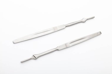 Çelik cerrahi aletler ve laboratuvar ekipmanları beyaz arka planda izole edilmiş. Profesyonel klinik aletleri. Tıbbi, cerrahi, ambulans ve veteriner konsepti. Yumuşak seçici odaklı yakın plan