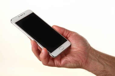 İnsan eli, avucunda boş bir krom ekran olan modern bir akıllı telefonu tutar. Teknoloji ve reklam kavramı. Ayrıntılı yakın çekim stüdyo çekimi soyut beyaz arka planda izole