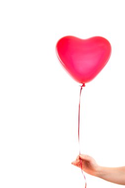 Kadın eli kırmızı kauçuk, şişme kalp şeklinde balon tutuyor. Aşk, ilişki, sevgililer günü ve doğum günü kutlaması konsepti. Stüdyo görüntüsü boş kopya alanı olan bulanık bir arkaplan üzerinde