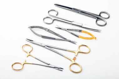 Çelik cerrahi aletler ve laboratuvar ekipmanları beyaz arka planda izole edilmiş. Profesyonel klinik aletleri. Tıbbi, cerrahi, ambulans ve veteriner konsepti. Yumuşak seçici odaklı yakın plan