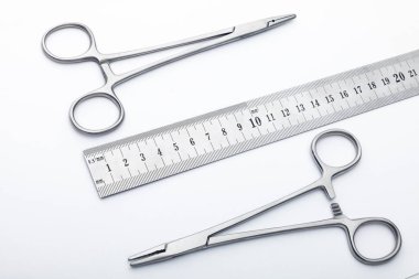 Çelik cerrahi aletler ve laboratuvar ekipmanları beyaz arka planda izole edilmiş. Profesyonel klinik aletleri. Tıbbi, cerrahi, ambulans ve veteriner konsepti. Yumuşak seçici odaklı yakın plan