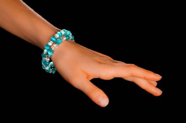 Güzel bir el yapımı mücevher bileziği. Renkli parlak boncuklar ve nötr manikürlü gevşek bir kadın bileği. Moda ve el işi aksesuarları. Yumuşak seçici odaklı yakın plan