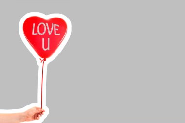 Kadın eli kırmızı kauçuk, şişme kalp şeklinde balon tutuyor. Aşk, ilişki, sevgililer günü ve doğum günü kutlaması konsepti. Boş kopya alanı olan dergi tarzı moda kolajı