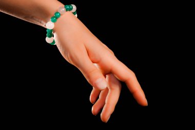 Güzel bir el yapımı mücevher bileziği. Renkli parlak boncuklar ve nötr manikürlü gevşek bir kadın bileği. Moda ve el işi aksesuarları. Yumuşak seçici odaklı yakın plan