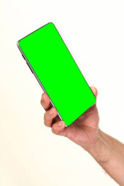 İnsan eli, avucunda boş bir krom ekran olan modern bir akıllı telefonu tutar. Teknoloji ve reklam kavramı. Ayrıntılı yakın çekim stüdyo çekimi soyut beyaz arka planda izole