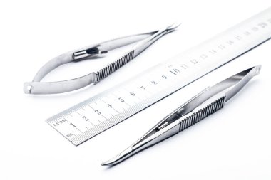 Çelik cerrahi aletler ve laboratuvar ekipmanları beyaz arka planda izole edilmiş. Profesyonel klinik aletleri. Tıbbi, cerrahi, ambulans ve veteriner konsepti. Yumuşak seçici odaklı yakın plan