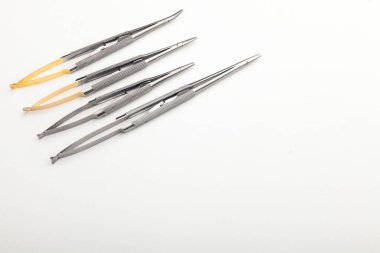 Çelik cerrahi aletler ve laboratuvar ekipmanları beyaz arka planda izole edilmiş. Profesyonel klinik aletleri. Tıbbi, cerrahi, ambulans ve veteriner konsepti. Yumuşak seçici odaklı yakın plan