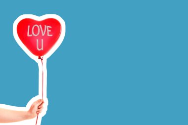 Kadın eli kırmızı kauçuk, şişme kalp şeklinde balon tutuyor. Aşk, ilişki, sevgililer günü ve doğum günü kutlaması konsepti. Boş kopya alanı olan dergi tarzı moda kolajı