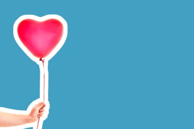 Kadın eli kırmızı kauçuk, şişme kalp şeklinde balon tutuyor. Aşk, ilişki, sevgililer günü ve doğum günü kutlaması konsepti. Boş kopya alanı olan dergi tarzı moda kolajı