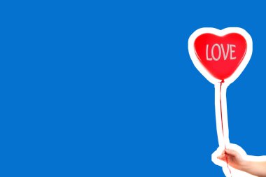 Kadın eli kırmızı kauçuk, şişme kalp şeklinde balon tutuyor. Aşk, ilişki, sevgililer günü ve doğum günü kutlaması konsepti. Boş kopya alanı olan dergi tarzı moda kolajı