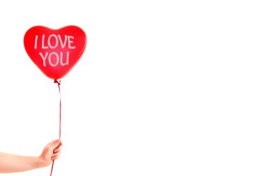 Kadın eli kırmızı kauçuk, şişme kalp şeklinde balon tutuyor. Aşk, ilişki, sevgililer günü ve doğum günü kutlaması konsepti. Stüdyo görüntüsü boş kopya alanı olan bulanık bir arkaplan üzerinde