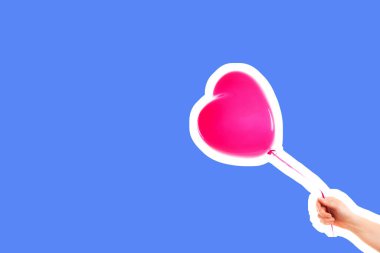 Kadın eli pembe kauçuk, şişme kalp şeklinde balon tutuyor. Aşk, ilişki, sevgililer günü ve doğum günü kutlaması konsepti. Boş kopya alanı olan dergi tarzı moda kolajı