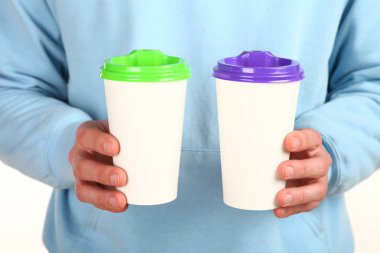 İnsan eli plastik kapaklı boş bir kahve fincanı tutar. Tek kullanımlık fincana çay ya da kahve konsepti. Metin veya logo için yeri ve yeri kopyala. Beyaz bir arkaplanda izole edilmiş