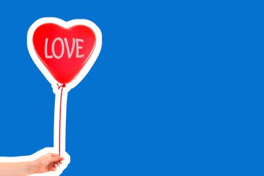 Kadın eli kırmızı kauçuk, şişme kalp şeklinde balon tutuyor. Aşk, ilişki, sevgililer günü ve doğum günü kutlaması konsepti. Boş kopya alanı olan dergi tarzı moda kolajı