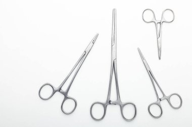 Çelik cerrahi aletler ve laboratuvar ekipmanları beyaz arka planda izole edilmiş. Profesyonel klinik aletleri. Tıbbi, cerrahi, ambulans ve veteriner konsepti. Yumuşak seçici odaklı yakın plan