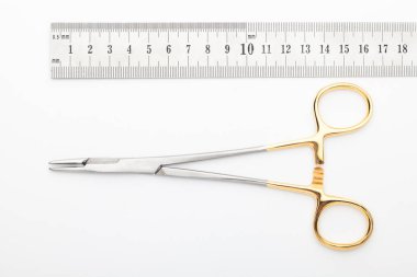 Çelik cerrahi aletler ve laboratuvar ekipmanları beyaz arka planda izole edilmiş. Profesyonel klinik aletleri. Tıbbi, cerrahi, ambulans ve veteriner konsepti. Yumuşak seçici odaklı yakın plan