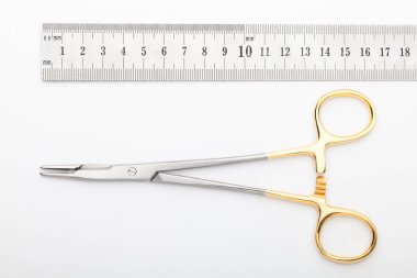 Çelik cerrahi aletler ve laboratuvar ekipmanları beyaz arka planda izole edilmiş. Profesyonel klinik aletleri. Tıbbi, cerrahi, ambulans ve veteriner konsepti. Yumuşak seçici odaklı yakın plan