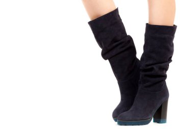 Bayan giysi ayakkabısı. Uzun ince dişinin bacakları yüksek topuklu uzun çizmeler giyer. Fotokopi alanı olan moda modeli. Klasik ve günlük kıyafet konsepti. Ayrıntılı yakın çekim stüdyo çekimi beyaz arkaplanda izole edildi