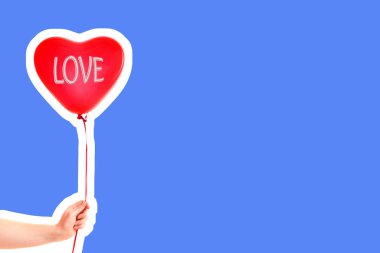 Kadın eli kırmızı kauçuk, şişme kalp şeklinde balon tutuyor. Aşk, ilişki, sevgililer günü ve doğum günü kutlaması konsepti. Boş kopya alanı olan dergi tarzı moda kolajı