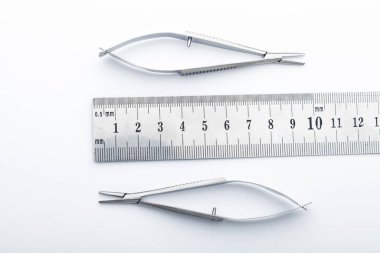 Çelik cerrahi aletler ve laboratuvar ekipmanları beyaz arka planda izole edilmiş. Profesyonel klinik aletleri. Tıbbi, cerrahi, ambulans ve veteriner konsepti. Yumuşak seçici odaklı yakın plan