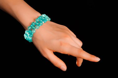 Güzel bir el yapımı mücevher bileziği. Renkli parlak boncuklar ve nötr manikürlü gevşek bir kadın bileği. Moda ve el işi aksesuarları. Yumuşak seçici odaklı yakın plan