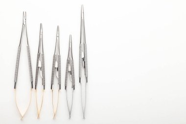 Çelik cerrahi aletler ve laboratuvar ekipmanları beyaz arka planda izole edilmiş. Profesyonel klinik aletleri. Tıbbi, cerrahi, ambulans ve veteriner konsepti. Yumuşak seçici odaklı yakın plan