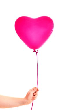 Kadın eli kırmızı kauçuk, şişme kalp şeklinde balon tutuyor. Aşk, ilişki, sevgililer günü ve doğum günü kutlaması konsepti. Stüdyo görüntüsü boş kopya alanı olan bulanık bir arkaplan üzerinde