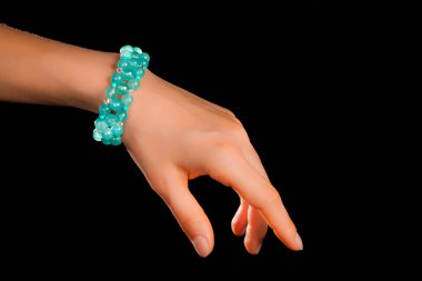 Güzel bir el yapımı mücevher bileziği. Renkli parlak boncuklar ve nötr manikürlü gevşek bir kadın bileği. Moda ve el işi aksesuarları. Yumuşak seçici odaklı yakın plan