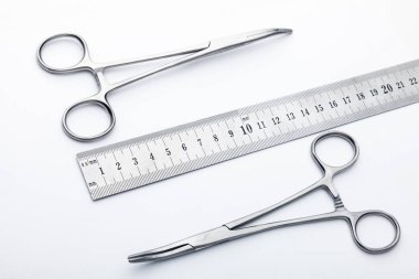 Çelik cerrahi aletler ve laboratuvar ekipmanları beyaz arka planda izole edilmiş. Profesyonel klinik aletleri. Tıbbi, cerrahi, ambulans ve veteriner konsepti. Yumuşak seçici odaklı yakın plan