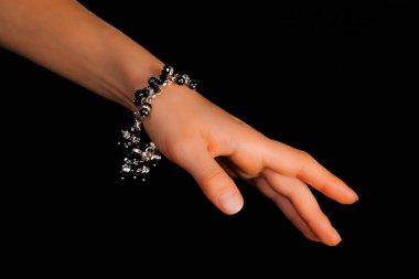 Güzel bir el yapımı mücevher bileziği. Renkli parlak boncuklar ve nötr manikürlü gevşek bir kadın bileği. Moda ve el işi aksesuarları. Yumuşak seçici odaklı yakın plan