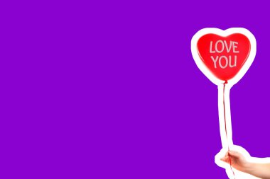 Kadın eli kırmızı kauçuk, şişme kalp şeklinde balon tutuyor. Aşk, ilişki, sevgililer günü ve doğum günü kutlaması konsepti. Boş kopya alanı olan dergi tarzı moda kolajı