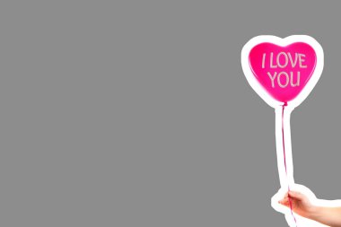 Kadın eli kırmızı kauçuk, şişme kalp şeklinde balon tutuyor. Aşk, ilişki, sevgililer günü ve doğum günü kutlaması konsepti. Boş kopya alanı olan dergi tarzı moda kolajı