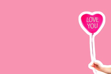 Kadın eli kırmızı kauçuk, şişme kalp şeklinde balon tutuyor. Aşk, ilişki, sevgililer günü ve doğum günü kutlaması konsepti. Boş kopya alanı olan dergi tarzı moda kolajı