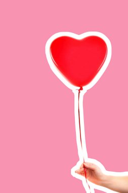 Kadın eli kırmızı kauçuk, şişme kalp şeklinde balon tutuyor. Aşk, ilişki, sevgililer günü ve doğum günü kutlaması konsepti. Boş kopya alanı olan dergi tarzı moda kolajı