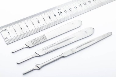 Çelik cerrahi aletler ve laboratuvar ekipmanları beyaz arka planda izole edilmiş. Profesyonel klinik aletleri. Tıbbi, cerrahi, ambulans ve veteriner konsepti. Yumuşak seçici odaklı yakın plan